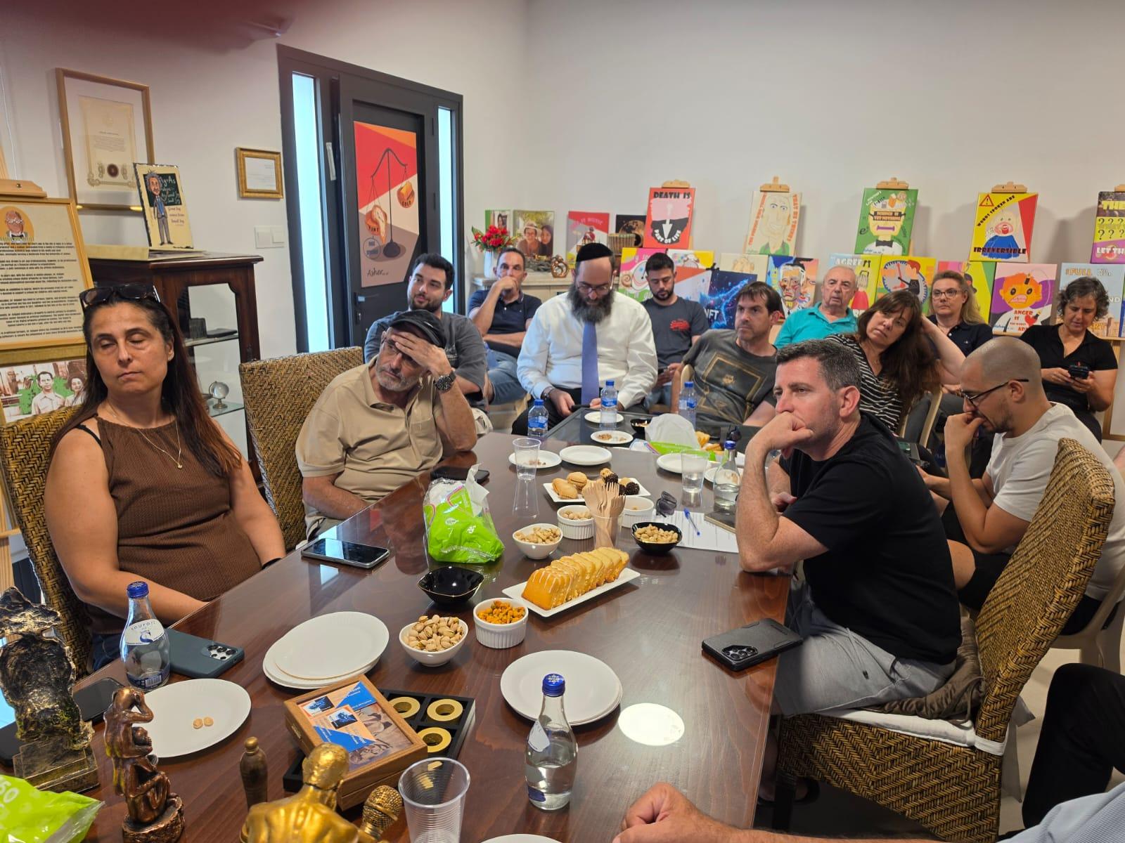 Attendees seated around the table listening to the lecture